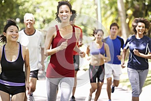 Group Of Runners Jogging Through Park