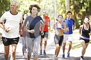 Group Of Runners Jogging Through Park