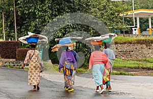 Group of Rwandan women in colorful traditionals clothes wearing washbowls on their heads, Kigali, Rwanda