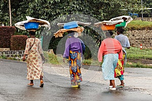 Group of Rwandan women in colorful traditionals clothes wearing washbowls on their heads, Kigali, Rwanda