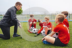 Group of sad boys with coach after loosing soccer tournament match