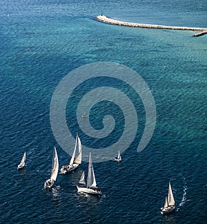 Group sailing boats and lighthouse at the sea