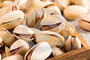 Group of salted pistachios in a small wooden box