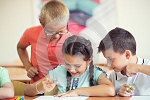 Group of school children learning at klassroom in school