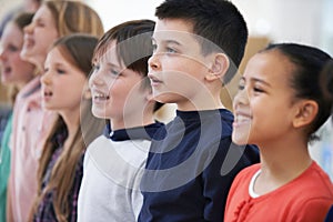 Group Of School Children Singing In Choir At Stage School Together