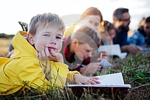 Group of school children with teacher on field trip in nature.