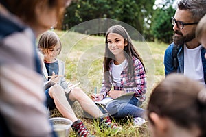 Group of school children with teacher on field trip in nature, learning science.