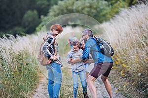 Group of school children with teacher on field trip in nature, running.