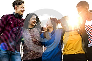 Group of school friends outdoors arms around one another togetherness and community concept