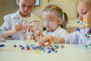 Group of school girl kids with teacher in school laboratory making experiment observing the chemical reaction with the