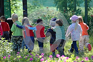Gruppo di giovani poco Caucasica della scuola i bambini in fila per tornare a scuola pre-primaria dopo un'escursione trekking all'aria aperta nell'autunno foresta alla scoperta della natura con un grande divertimento.