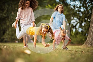 Group of school kids having fun in nature. Focus is on foreground.  Funny time