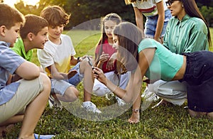 Group of school kids learning about nature and looking at insects through magnifying glass