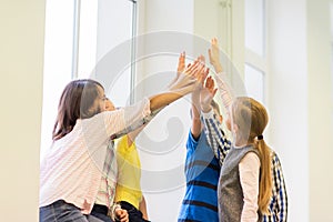 Group of school kids making high five gesture photo