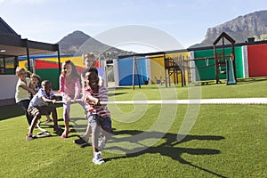 Group of school kids playing tug of war