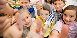 Group of school kids showing thumbs up