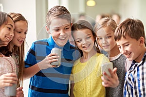 Group of school kids with smartphone and soda cans