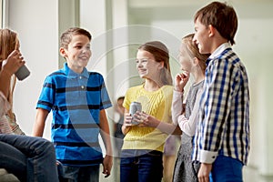 Group of school kids with soda cans in corridor