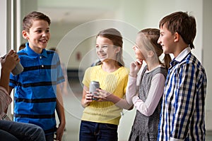 Group of school kids with soda cans in corridor