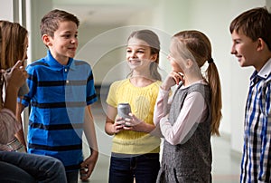 Group of school kids with soda cans in corridor