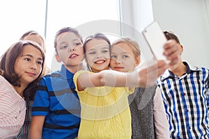 Group of school kids taking selfie with smartphone