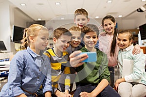 Group of school kids taking selfie with smartphone