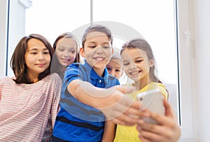 Group of school kids taking selfie with smartphone