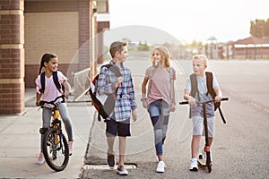 Group of school kids talking and walking home from school together