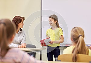 Group of school kids with teacher in classroom