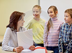 Group of school kids with teacher in classroom