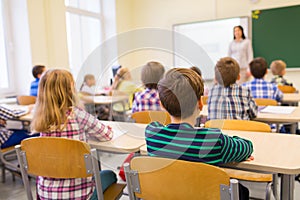 Group of school kids and teacher in classroom