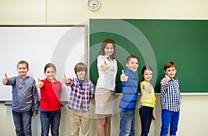 Group of school kids and teacher showing thumbs up