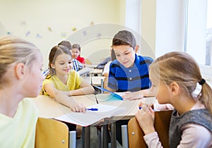 Group of school kids writing test in classroom