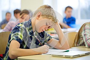 Group of school kids writing test in classroom