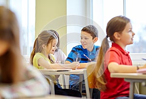 Group of school kids writing test in classroom