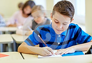 Group of school kids writing test in classroom