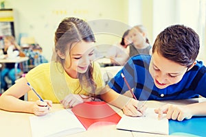 Group of school kids writing test in classroom