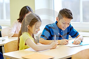 Group of school kids writing test in classroom