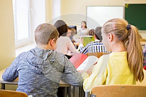 Group of school kids writing test in classroom