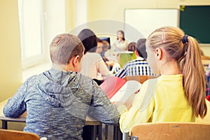 Group of school kids writing test in classroom
