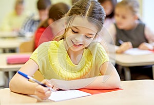 Group of school kids writing test in classroom