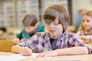 Group of school kids writing test in classroom