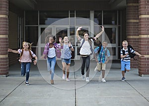 Group school school kids running as they leave the school building