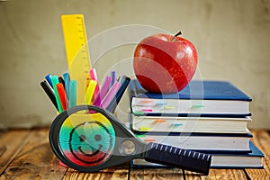 Group of school supplies and books and red apple over on backgro