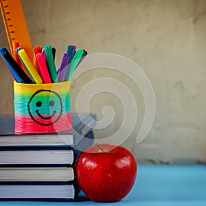 Group of school supplies and books and red apple over on background.School, stationary, equipment.