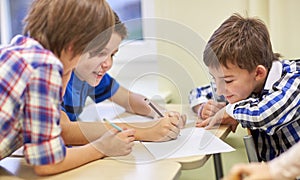 Group of schoolboys writing or drawing at school photo