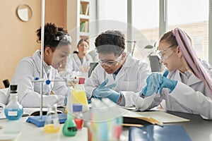 Group of schoolchildren enjoying science experiments in class