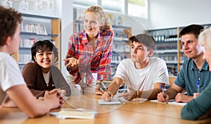 Group of schoolchildren in the school library, discussing something