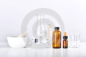 Group of scientific laboratory glassware with medicine bottles and clear liquid solution, Drug research