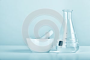 Group of scientific laboratory glassware and mortar with clear liquid solution, Research